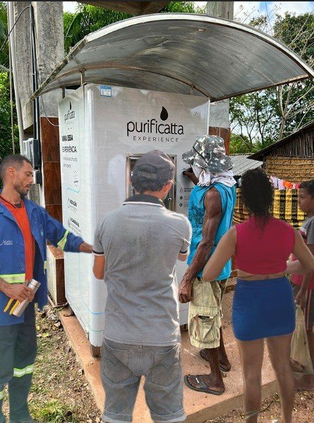 Moradores enchendo galões na máquina Comunitá