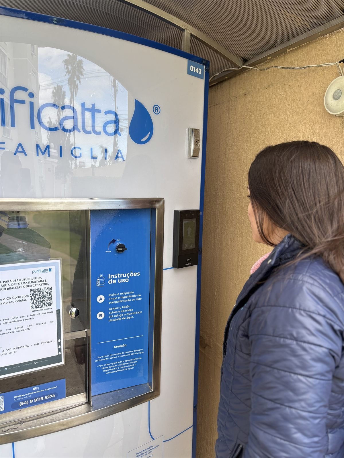Moradora em frente à Famiglia, com as instruções de uso